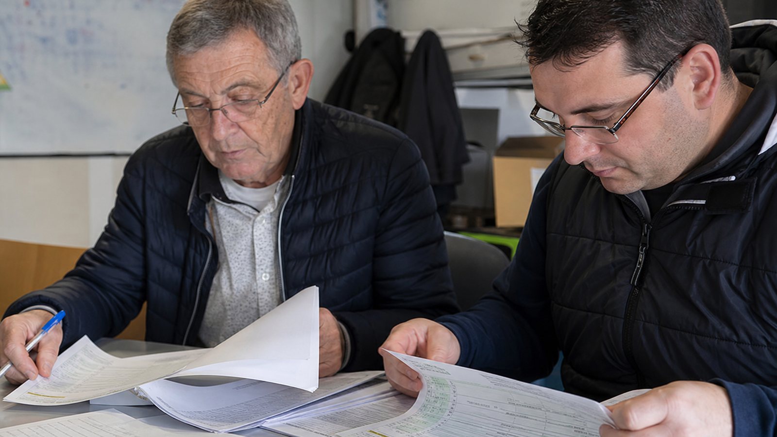 Dirigeants d'un club et de la ligue échangeant autour d'un même document