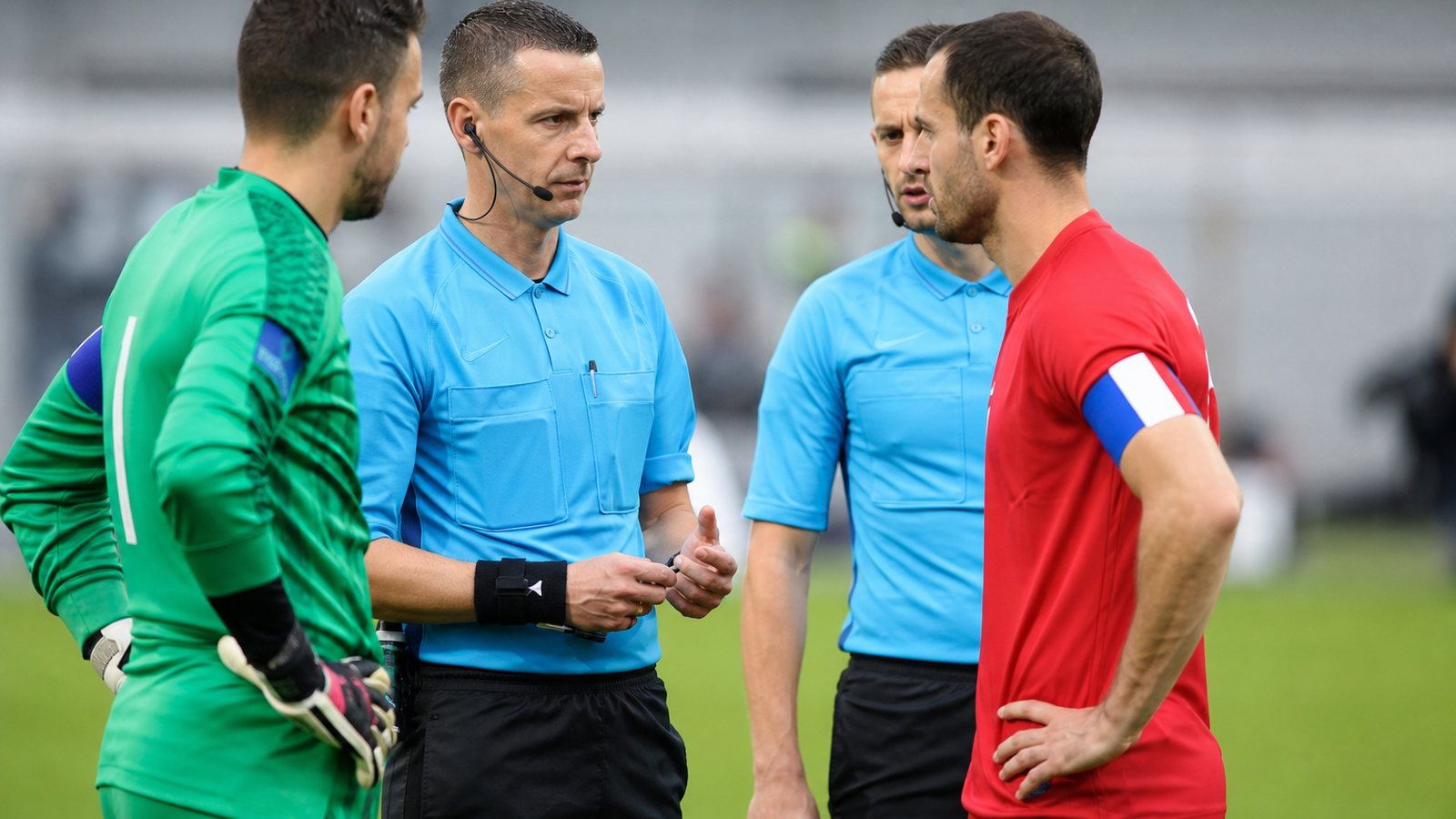 Capitaine relisant la feuille de match avec l'arbitre avant de la signer